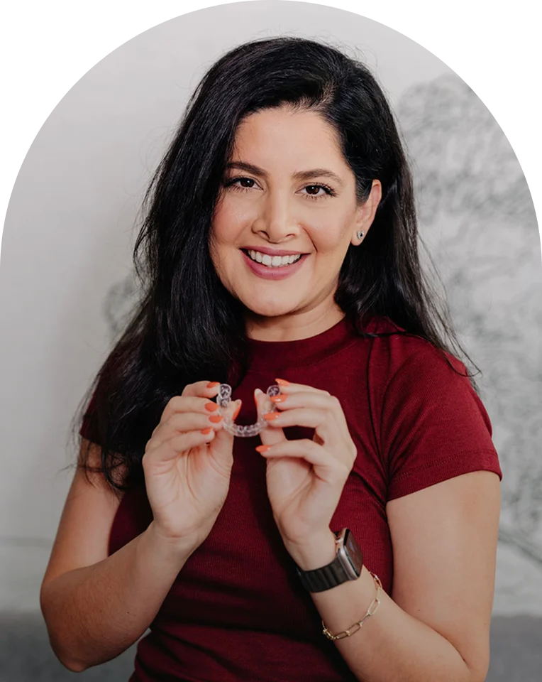 Patient holding a clear Invisalign aligner at Enamyl Dentistry