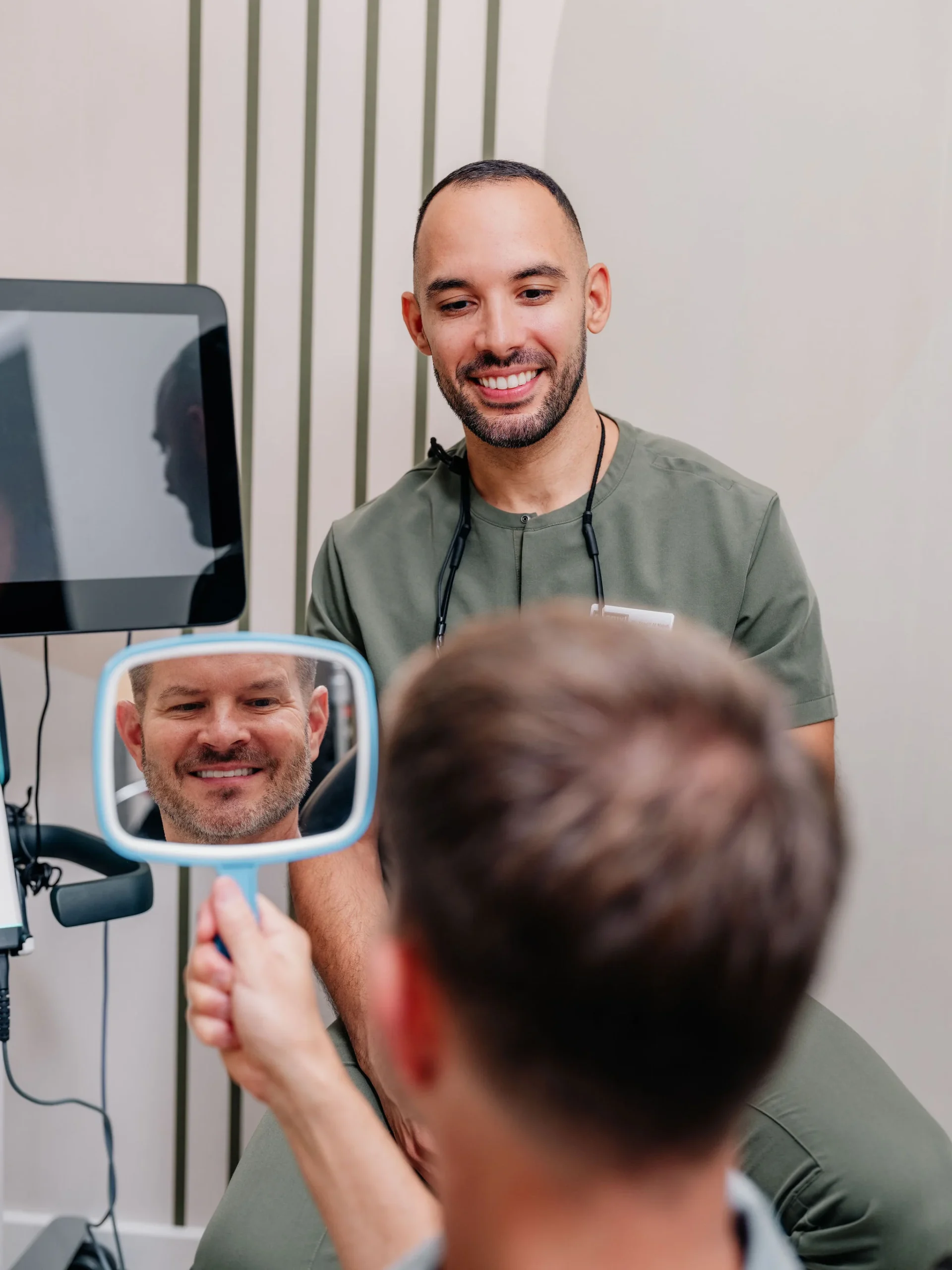 A patient reviewing their smile on screen with the Enamyl Dentistry team